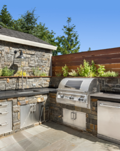 Custom outdoor kitchen with stone countertops and built-in grill